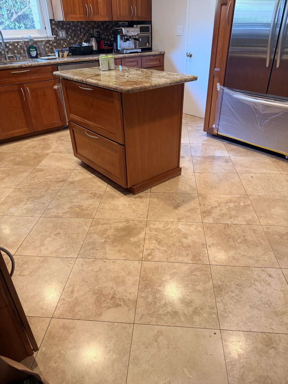The same kitchen travertine floor before restoration, dull and soiled