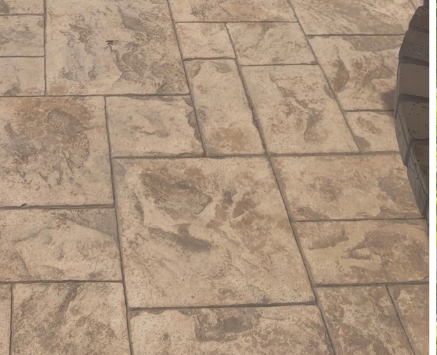 Faded stamped-concrete patio before cleaning and staining