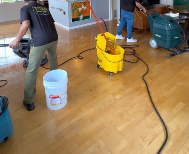 Wood floor during cleaning with equipment and workers